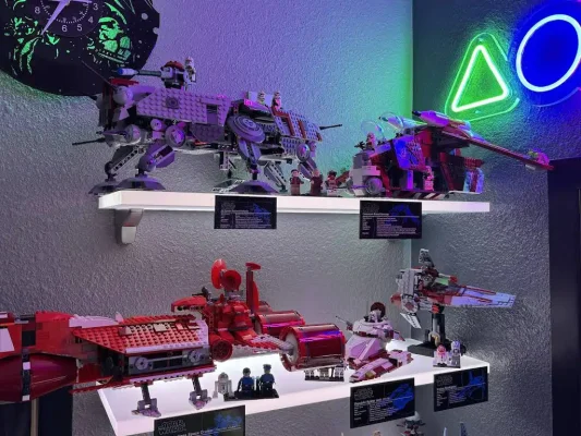 Close-up of white LED floating shelves with cool white light displaying Lego Star Wars Republic Gunship, AT-TE, and Frigate sets with custom plaques.